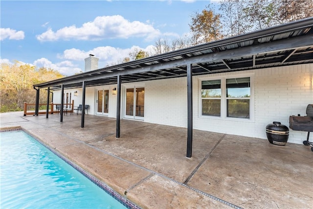 10729 Anzac Dr, Lowell, AR 72745 - rear view of property featuring a chimney, a patio area, an outdoor pool, and brick siding