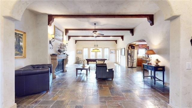 living room featuring beamed ceiling, sink, ceiling fan, and billiards