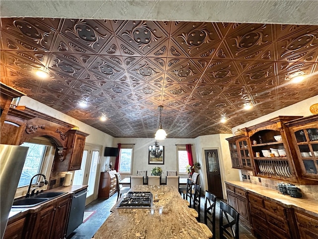 kitchen with plenty of natural light, sink, light stone counters, and appliances with stainless steel finishes