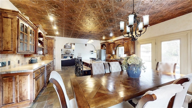 dining space featuring sink and an inviting chandelier