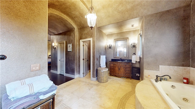 bathroom with tile patterned flooring, vanity, a bathtub, and vaulted ceiling