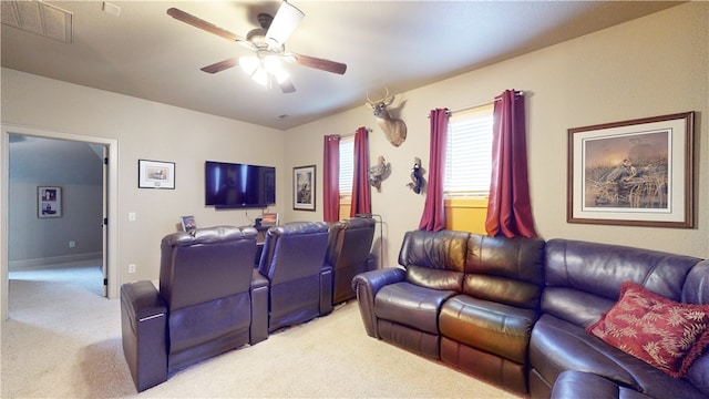 carpeted home theater room with ceiling fan