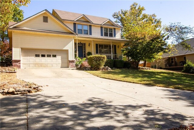 craftsman inspired home with covered porch, a front lawn, and a garage