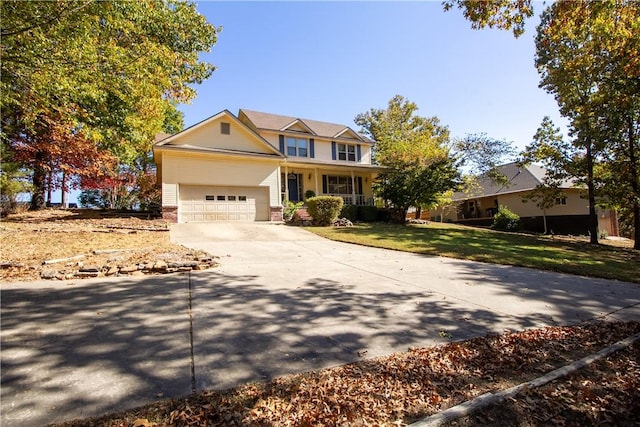 view of front of home featuring covered porch, a front yard, and a garage