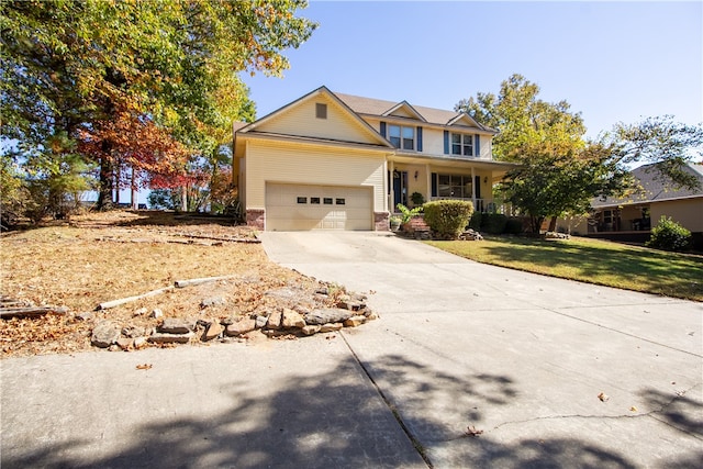 view of front of home featuring a garage, covered porch, and a front lawn