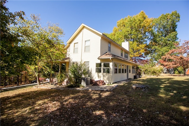 view of property exterior with a lawn and central AC