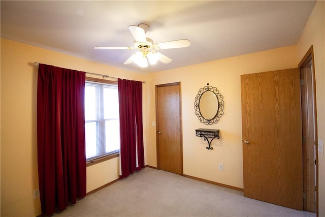 unfurnished bedroom featuring light carpet and ceiling fan