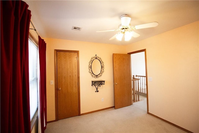 spare room featuring ceiling fan and light colored carpet