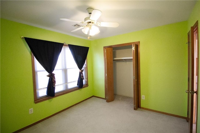 unfurnished bedroom featuring light carpet, a closet, and ceiling fan