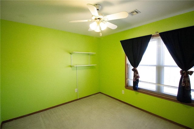 carpeted spare room with ceiling fan