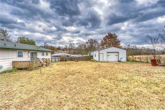 view of yard featuring a garage, an outdoor structure, and a wooden deck