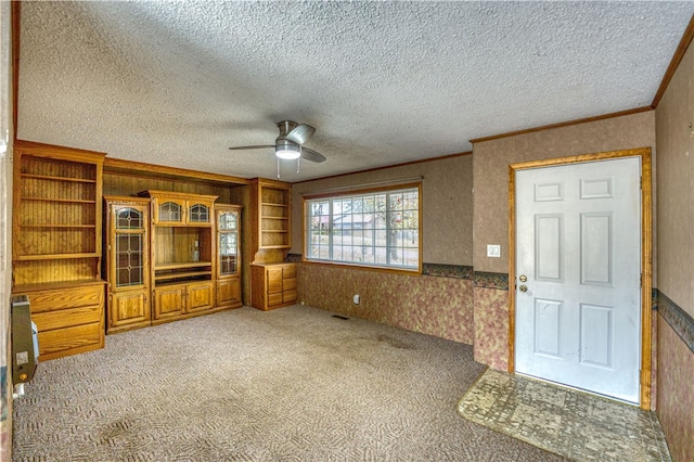 unfurnished living room with ceiling fan, a textured ceiling, and carpet floors