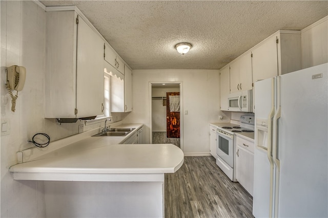 kitchen with white appliances, dark hardwood / wood-style floors, sink, white cabinets, and kitchen peninsula