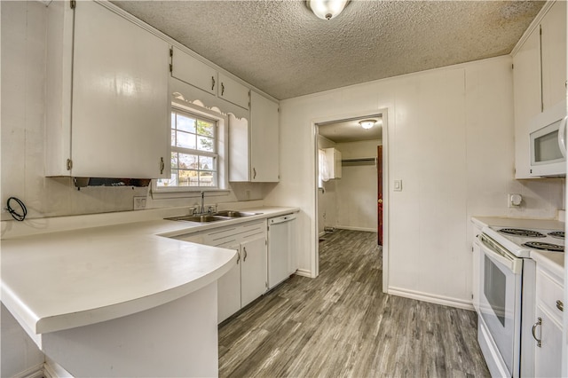 kitchen with white appliances, white cabinetry, and dark hardwood / wood-style flooring