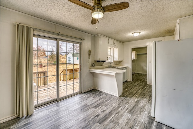 kitchen featuring white refrigerator, white cabinets, a textured ceiling, ceiling fan, and light hardwood / wood-style flooring