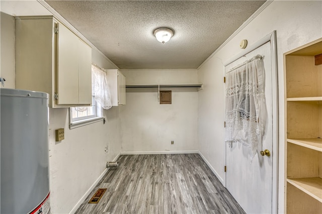 laundry area with hardwood / wood-style flooring, a textured ceiling, gas water heater, and crown molding