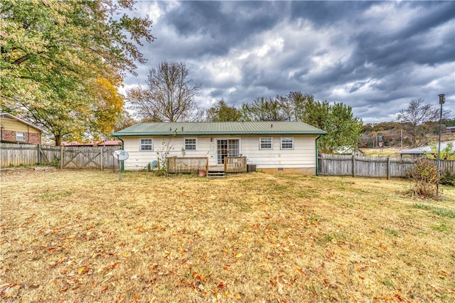 back of house featuring a wooden deck and a lawn