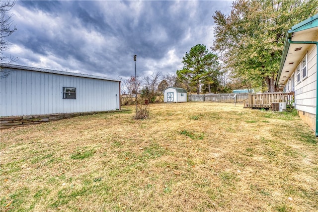 view of yard featuring a storage shed and central AC unit