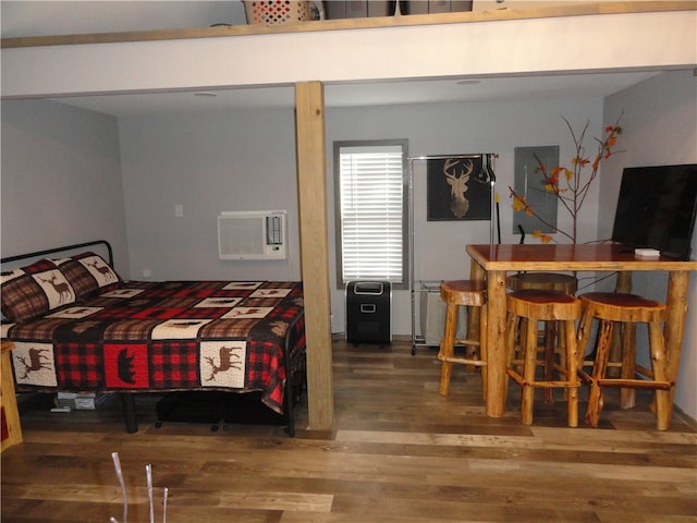 bedroom featuring wood-type flooring and a wall mounted AC