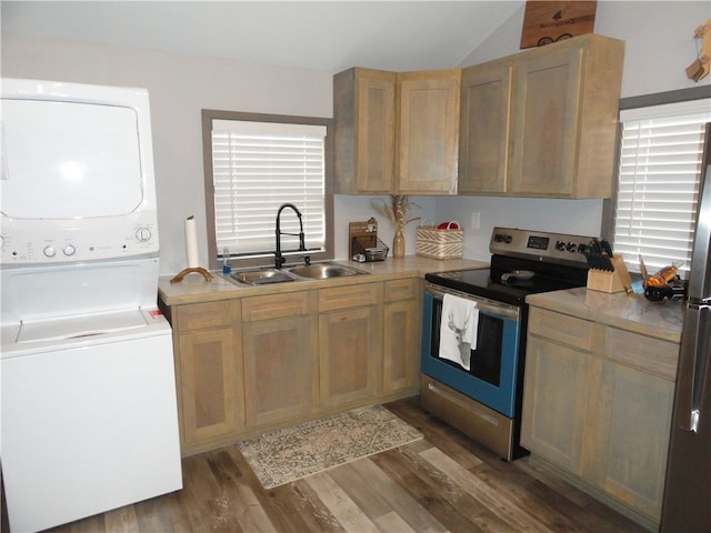 kitchen featuring stainless steel appliances, dark hardwood / wood-style flooring, vaulted ceiling, stacked washer and clothes dryer, and sink