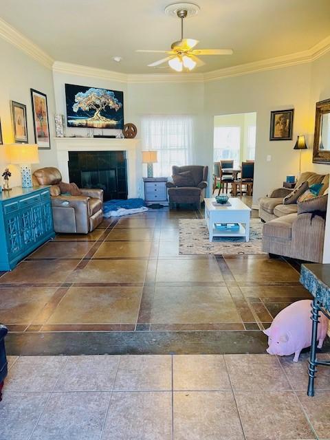 living room with crown molding and ceiling fan