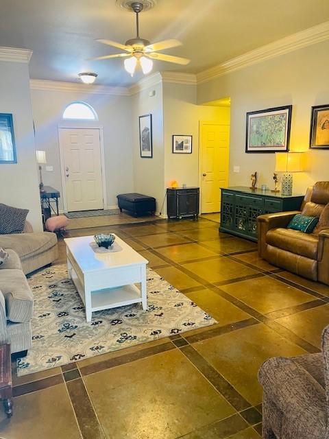 living room featuring ceiling fan, ornamental molding, and dark tile patterned floors