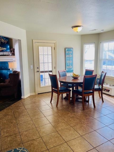 dining room with a textured ceiling and light tile patterned flooring