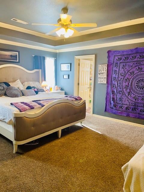 carpeted bedroom with ornamental molding and ceiling fan