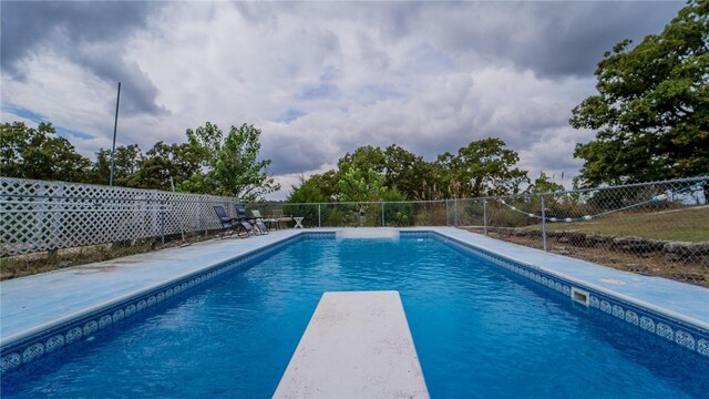 view of pool with a diving board