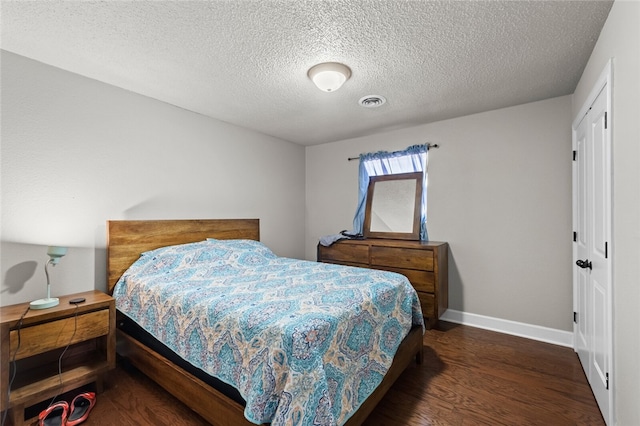 bedroom with dark wood-type flooring and a textured ceiling