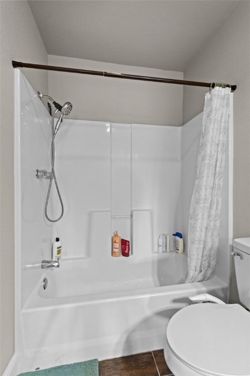 bathroom with a shower with shower curtain and toilet