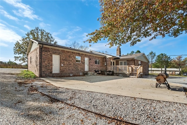 rear view of house featuring a patio area and a wooden deck