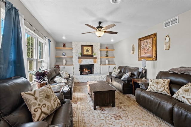 living room featuring ceiling fan and a fireplace