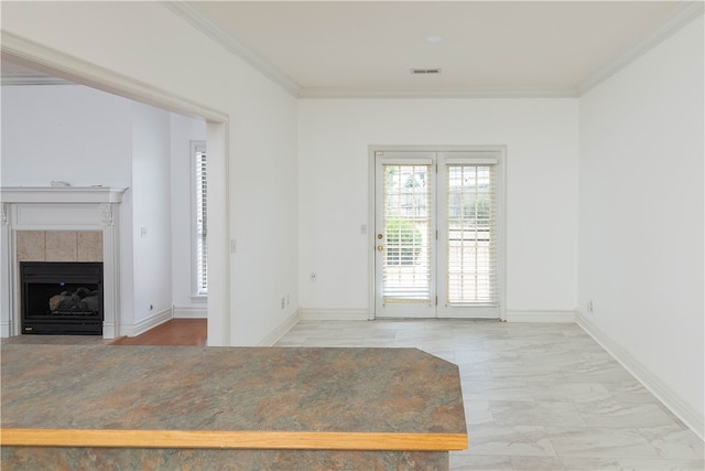 interior space with a tile fireplace and ornamental molding