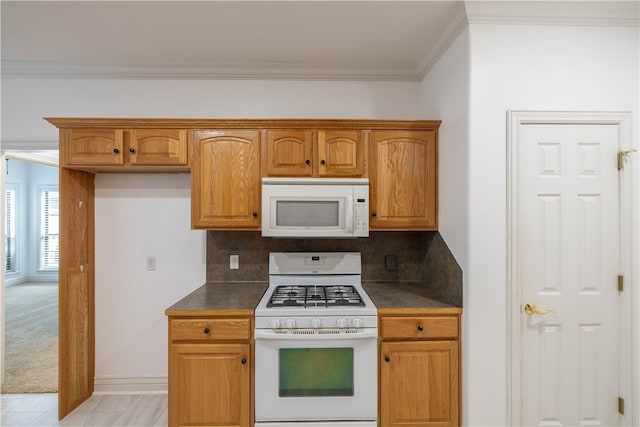 kitchen with white appliances, decorative backsplash, light carpet, and crown molding