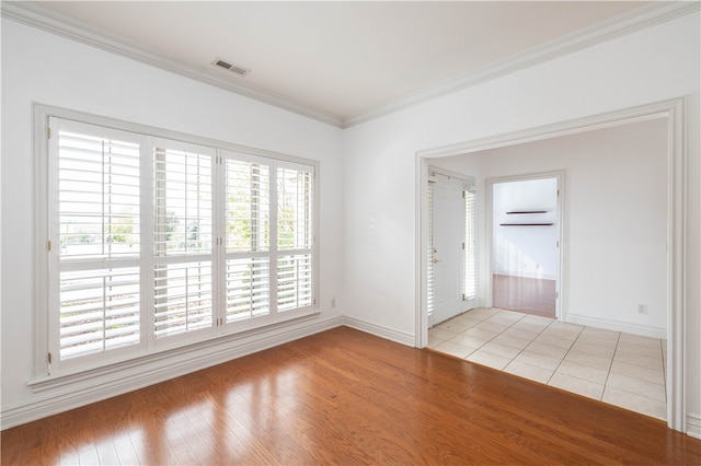 empty room with light wood-type flooring and crown molding