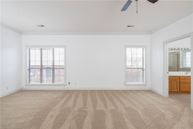 interior space featuring multiple windows, light colored carpet, ceiling fan, and connected bathroom