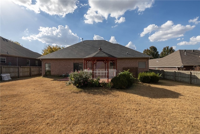 rear view of property featuring a lawn