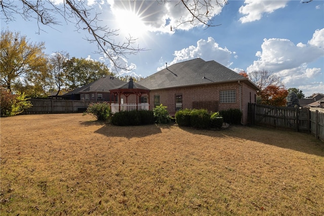 back of house with a yard and a gazebo