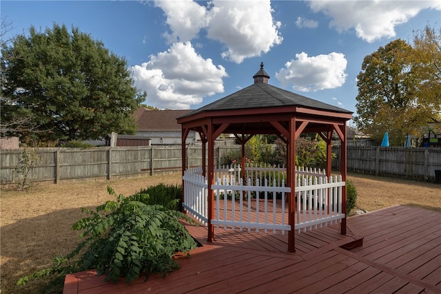 wooden deck featuring a lawn and a gazebo