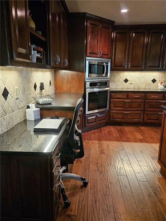 kitchen featuring light hardwood / wood-style floors, dark brown cabinetry, backsplash, and appliances with stainless steel finishes