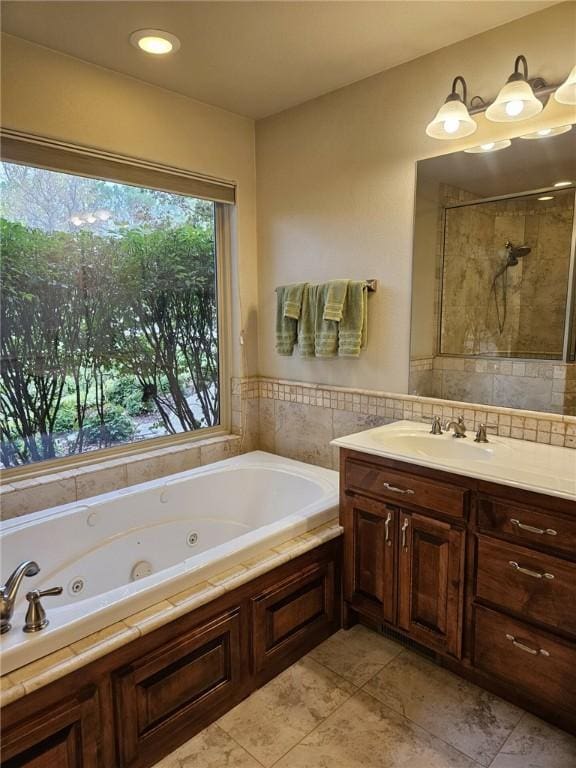 bathroom with tile patterned flooring, vanity, and shower with separate bathtub