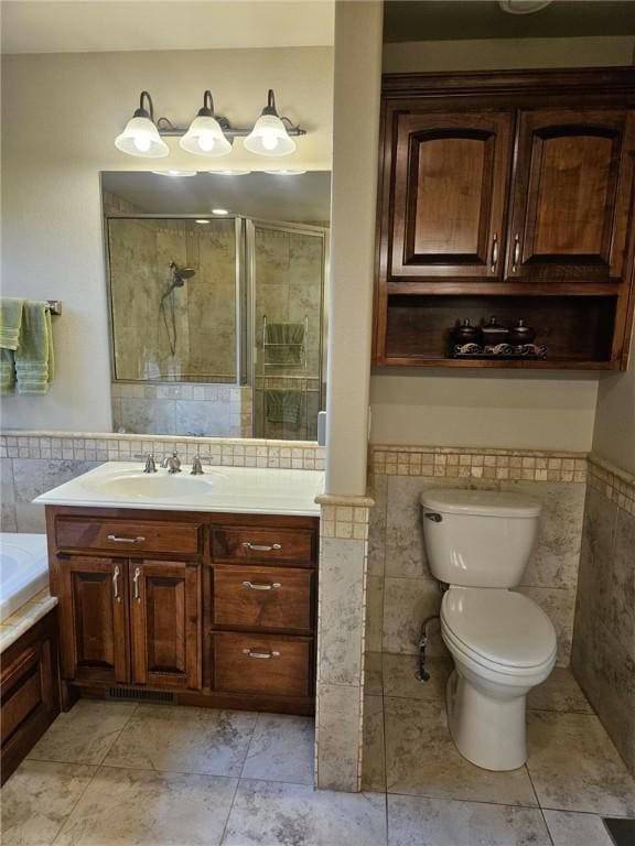 full bathroom featuring vanity, shower with separate bathtub, toilet, and tile walls