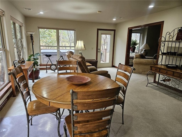 dining room with light carpet and a healthy amount of sunlight