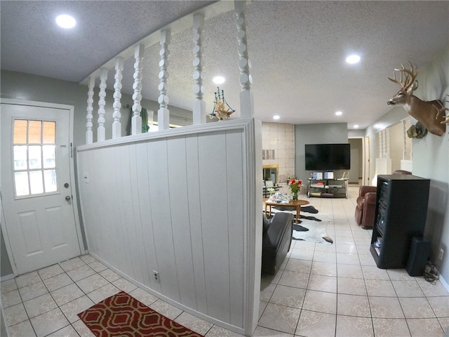 interior space with a textured ceiling and light tile patterned floors