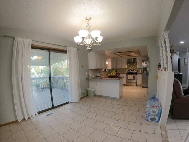 kitchen with light tile patterned flooring, kitchen peninsula, appliances with stainless steel finishes, a chandelier, and white cabinets