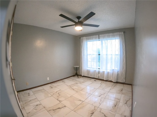 empty room with a textured ceiling and ceiling fan