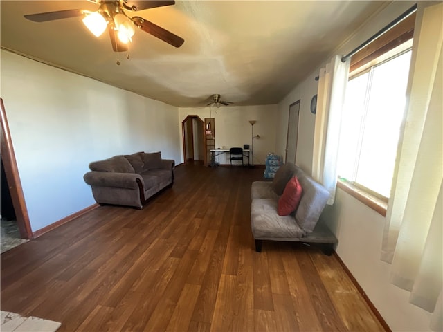 living room featuring ceiling fan and dark hardwood / wood-style flooring