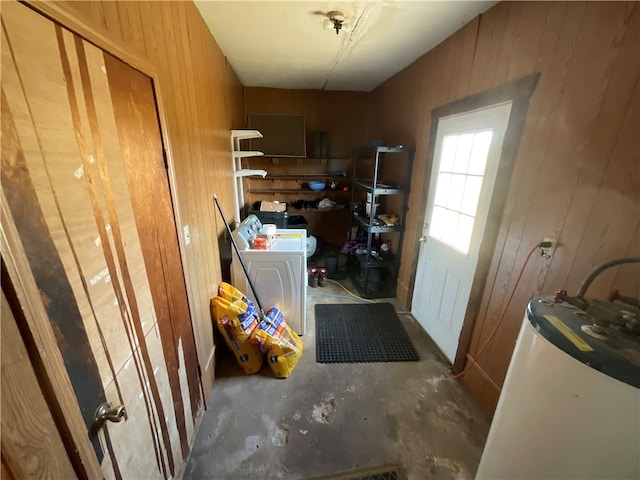 laundry room featuring water heater, washer / clothes dryer, and wooden walls