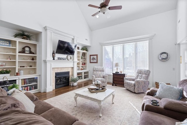 1303 NW Hermanus St, Bentonville, AR 72712 - living room featuring ceiling fan, wood finished floors, high vaulted ceiling, and a tile fireplace